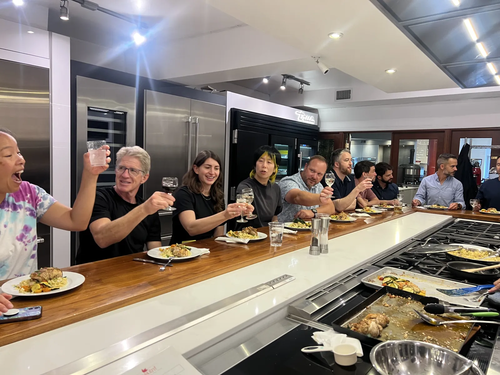 Group toasting together at the Atherton Appliance showroom kitchen