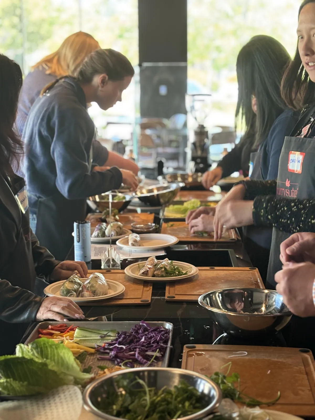 Group preparing fresh spring rolls together at a wellness cooking class