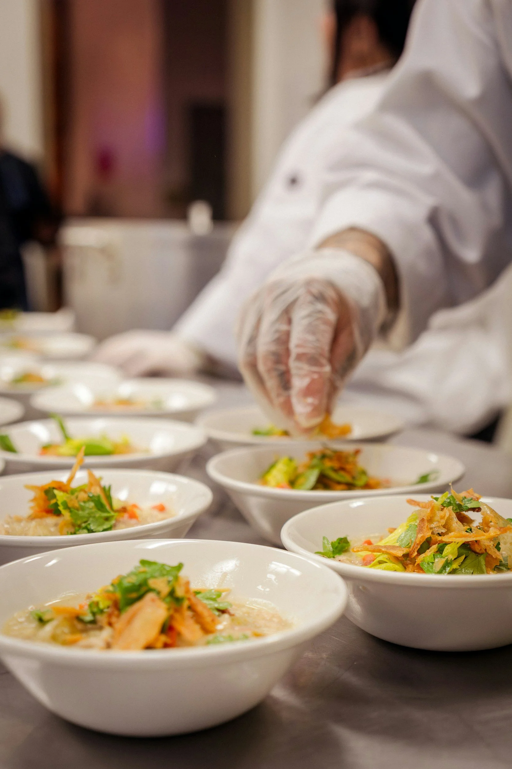 Chef plating individual dishes for a live chef's table
