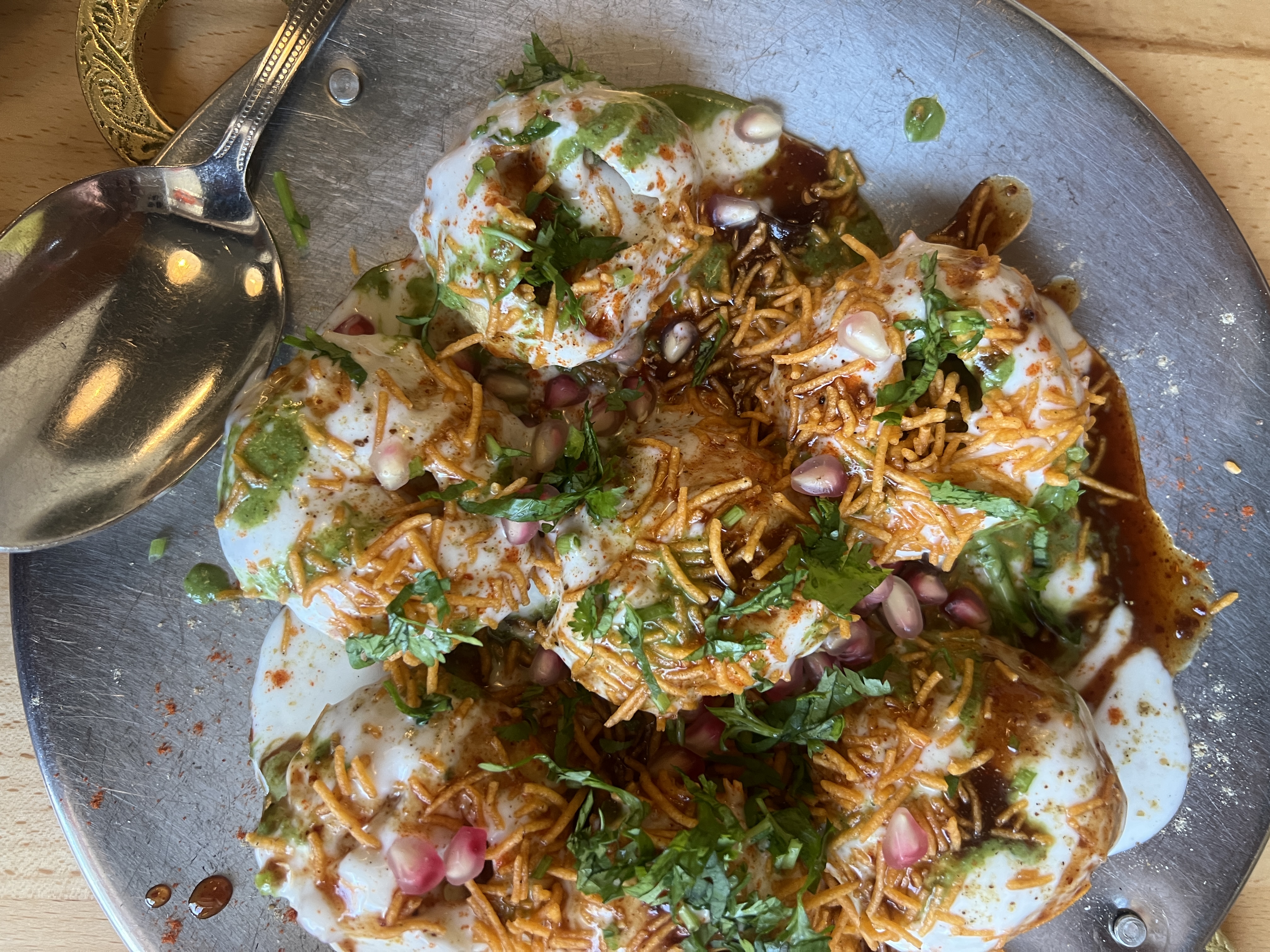 Papdi chaat topped with pomegranate, yogurt, and sev