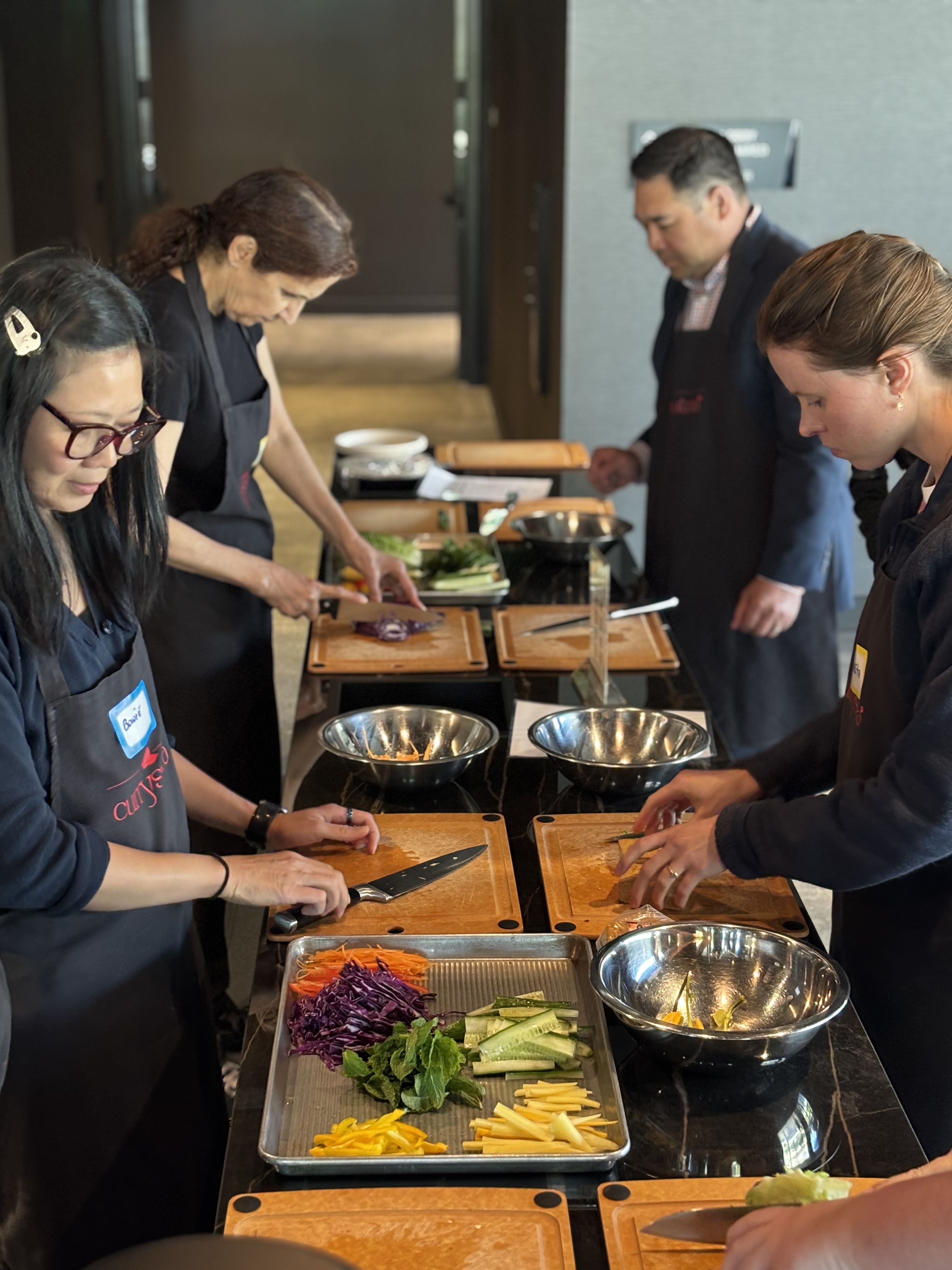 Team chopping fresh vegetables during a wellness cooking session