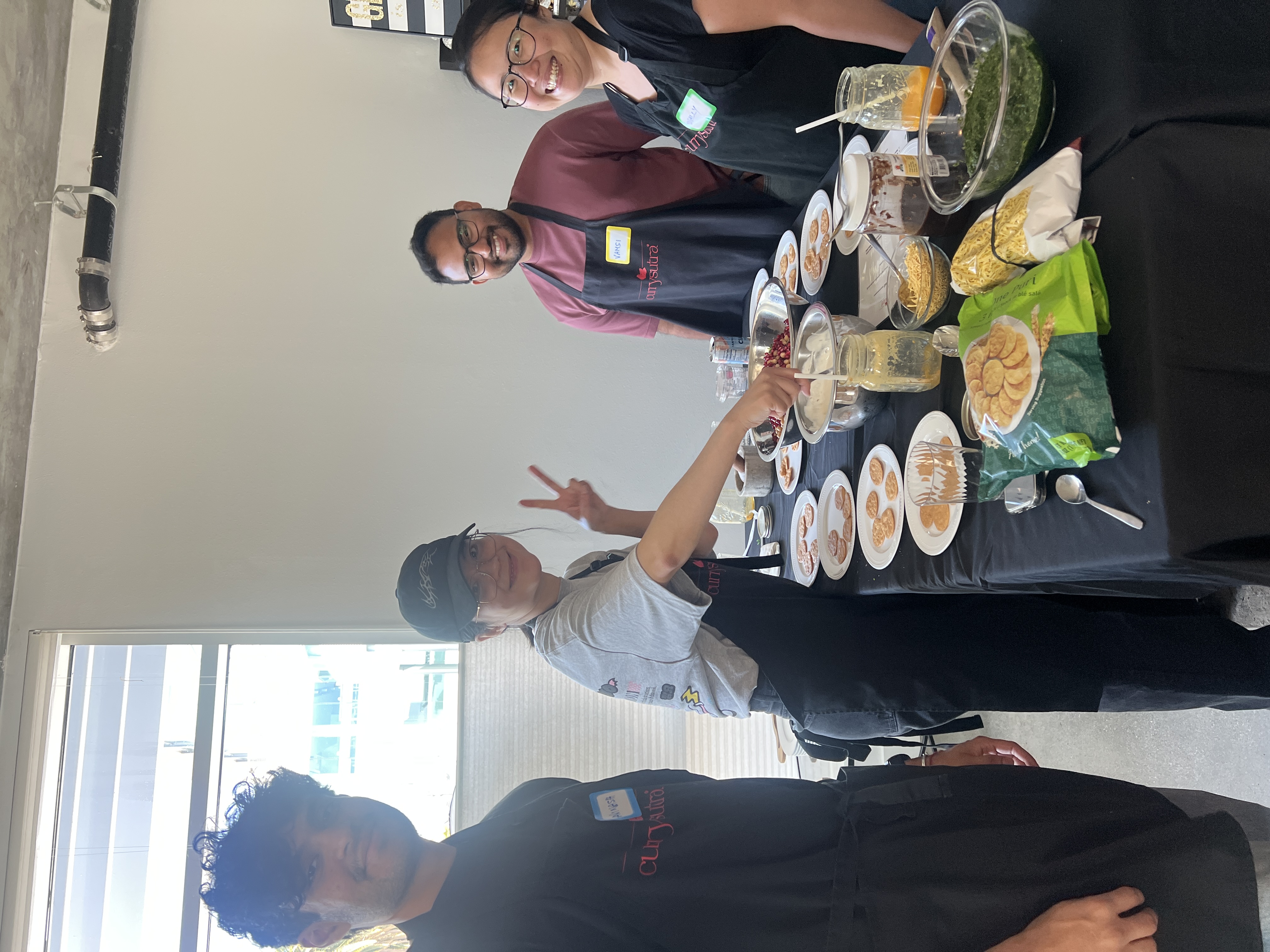 Team assembling bite-sized appetizers together with Currysutra aprons